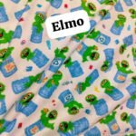 Elmo digital lawn fabric featuring Oscar the Grouch in blue trash cans with fun expressions on a light background – 45" width