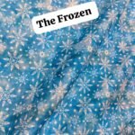 Frozen-themed digital lawn fabric with white snowflakes scattered over a gradient blue background – 45” wide